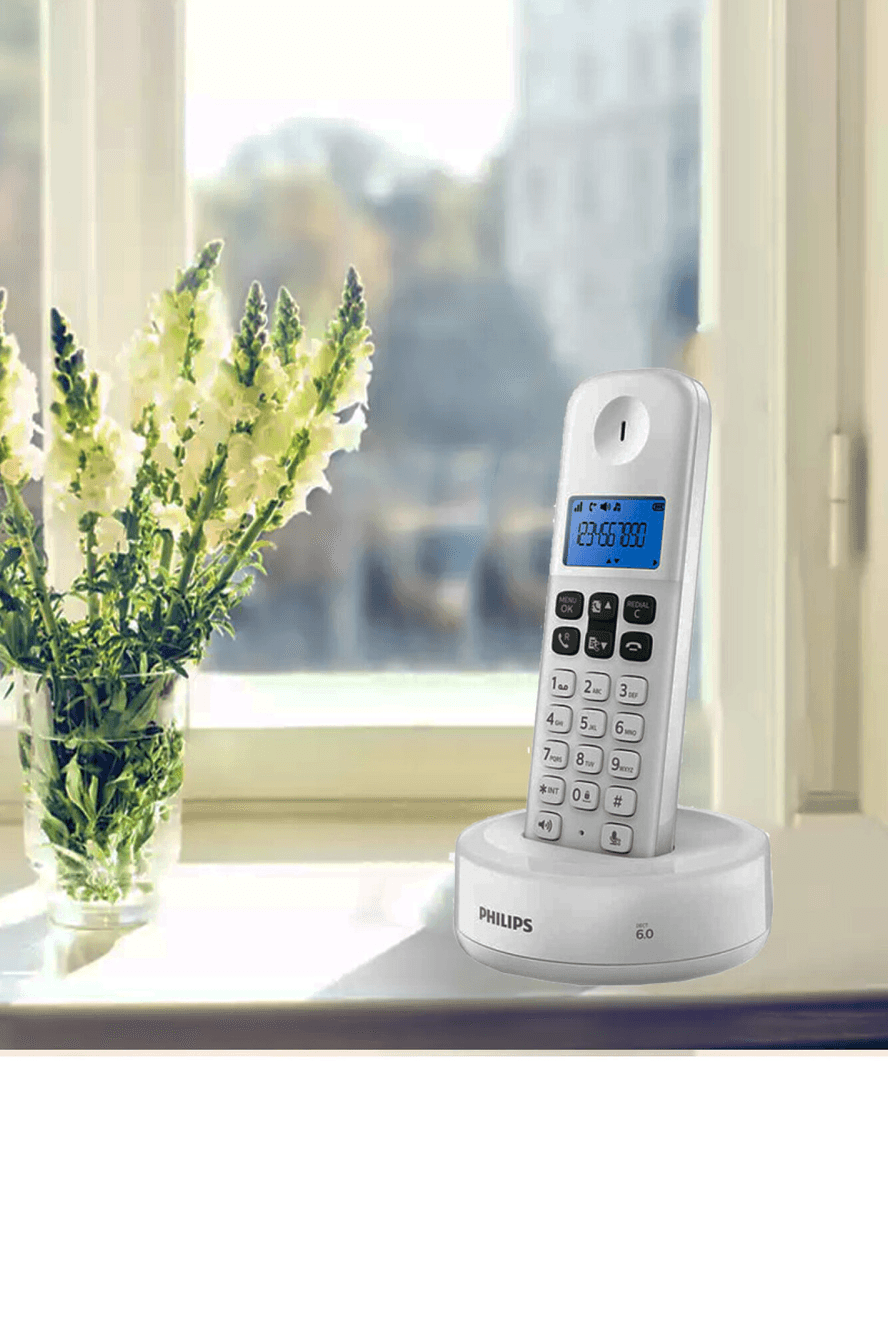 Teléfono inalámbrico Philips D1311W77 sobre una ventana