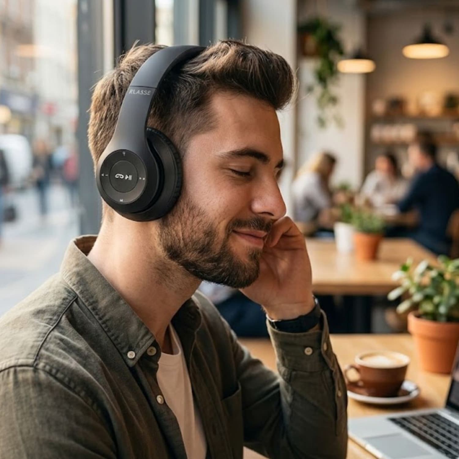 Hombre usando los auriculares Klasse KS2300 en un café