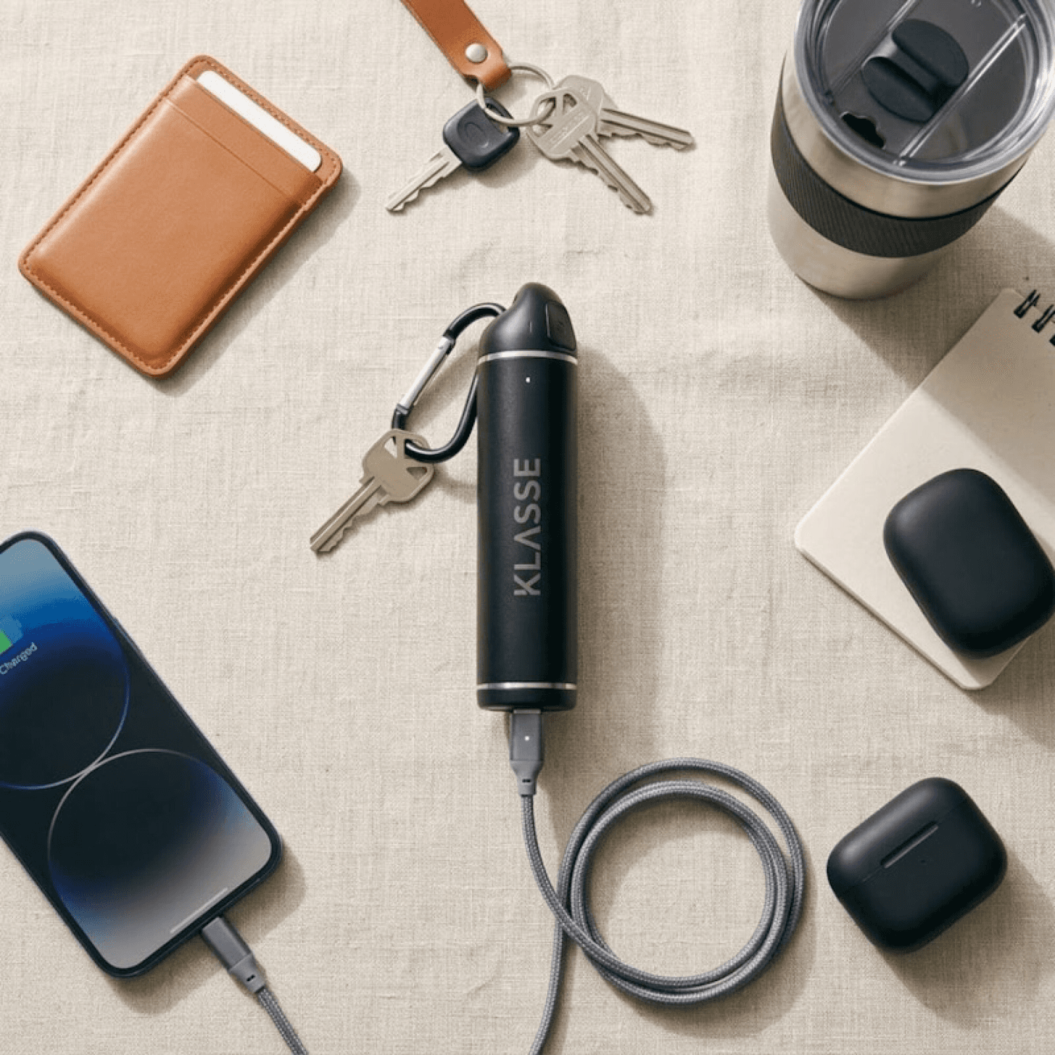 Power bank Klasse KS3100 junto a un celular y llaves