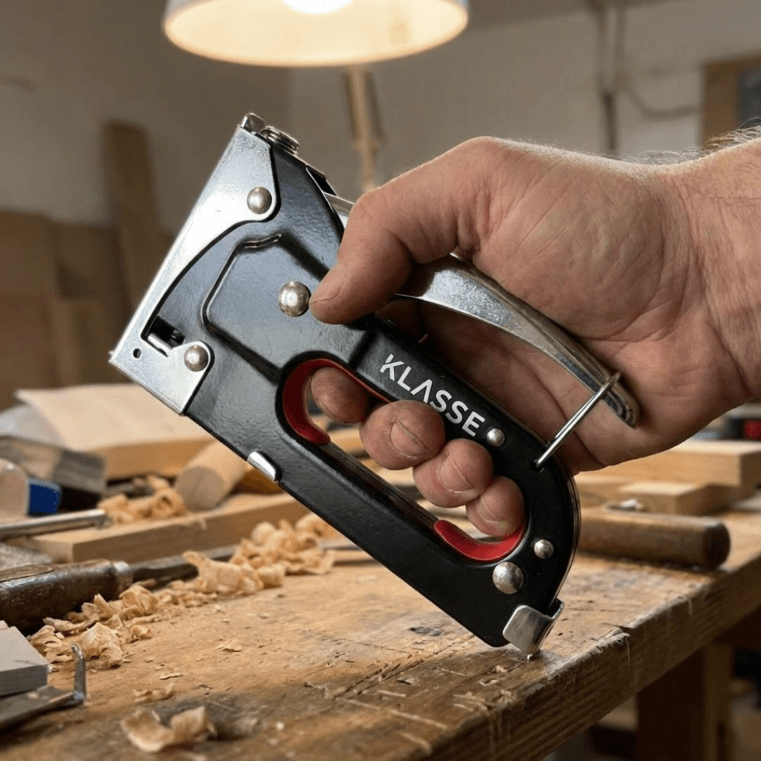 Engrapadora Klasse KS7705 en la mano sobre mesa de carpintería