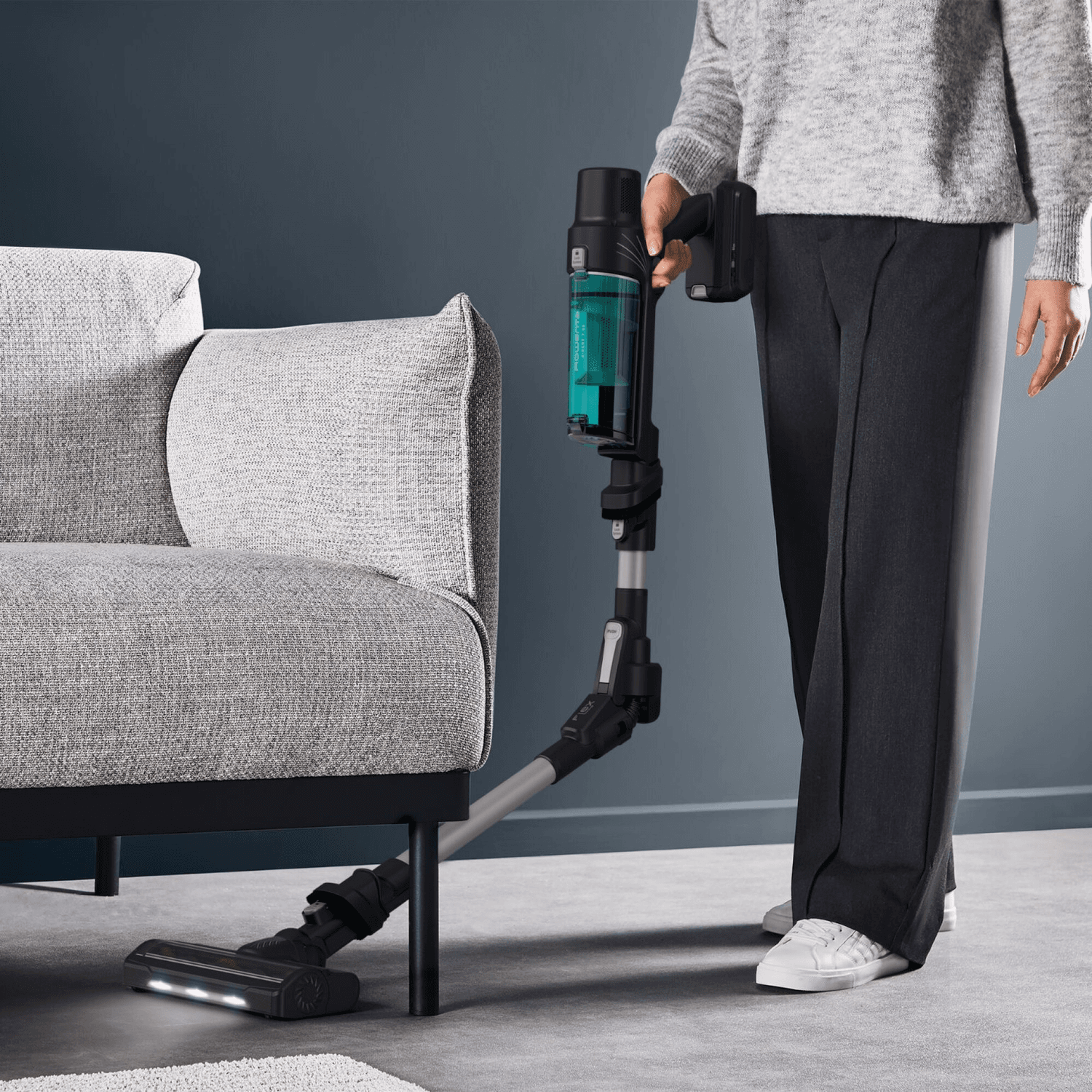 Rowenta RH6A42WO limpiando el piso junto a un sillón