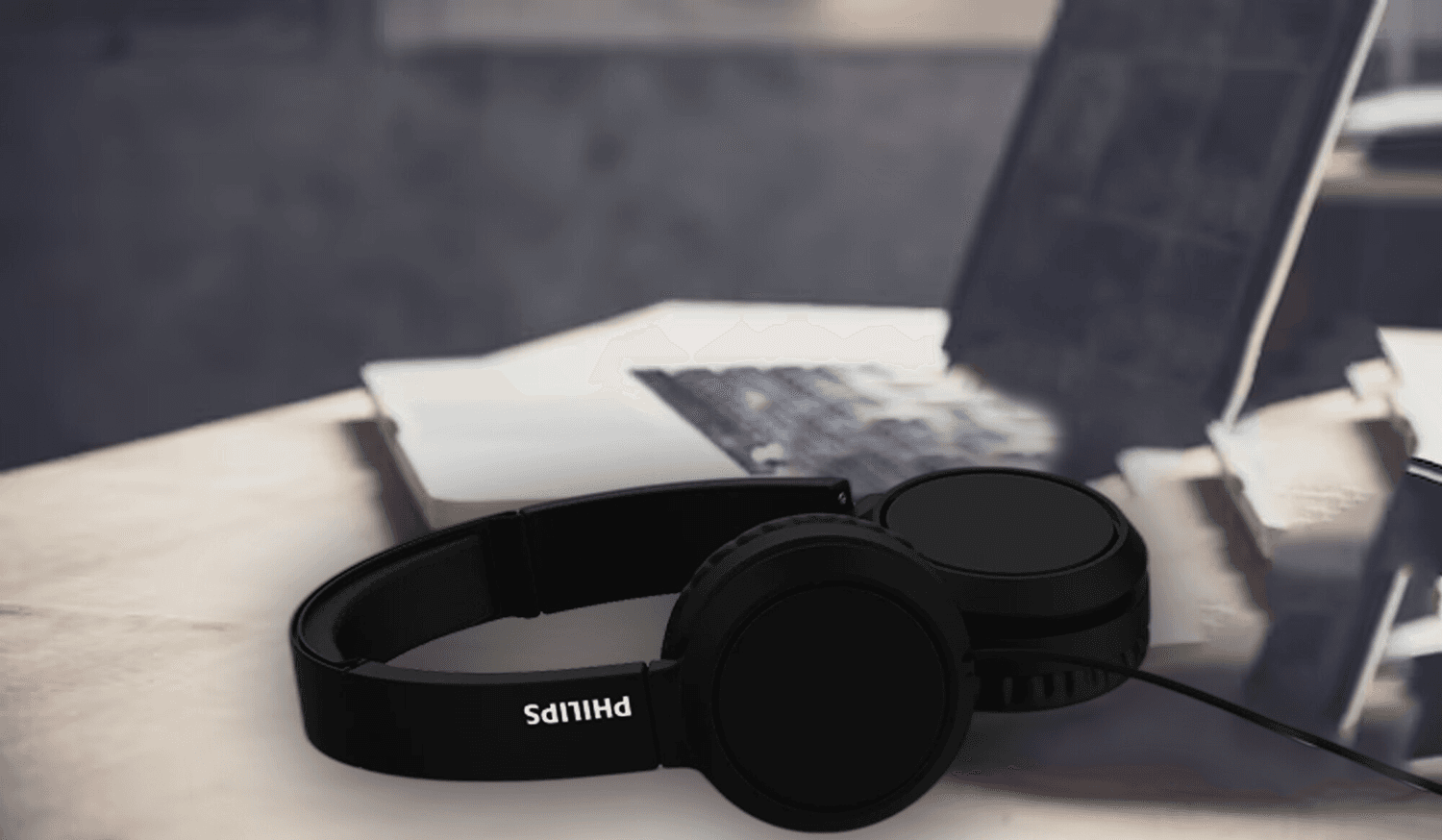 Auriculares Philips TAH4105/00 junto a una notebook