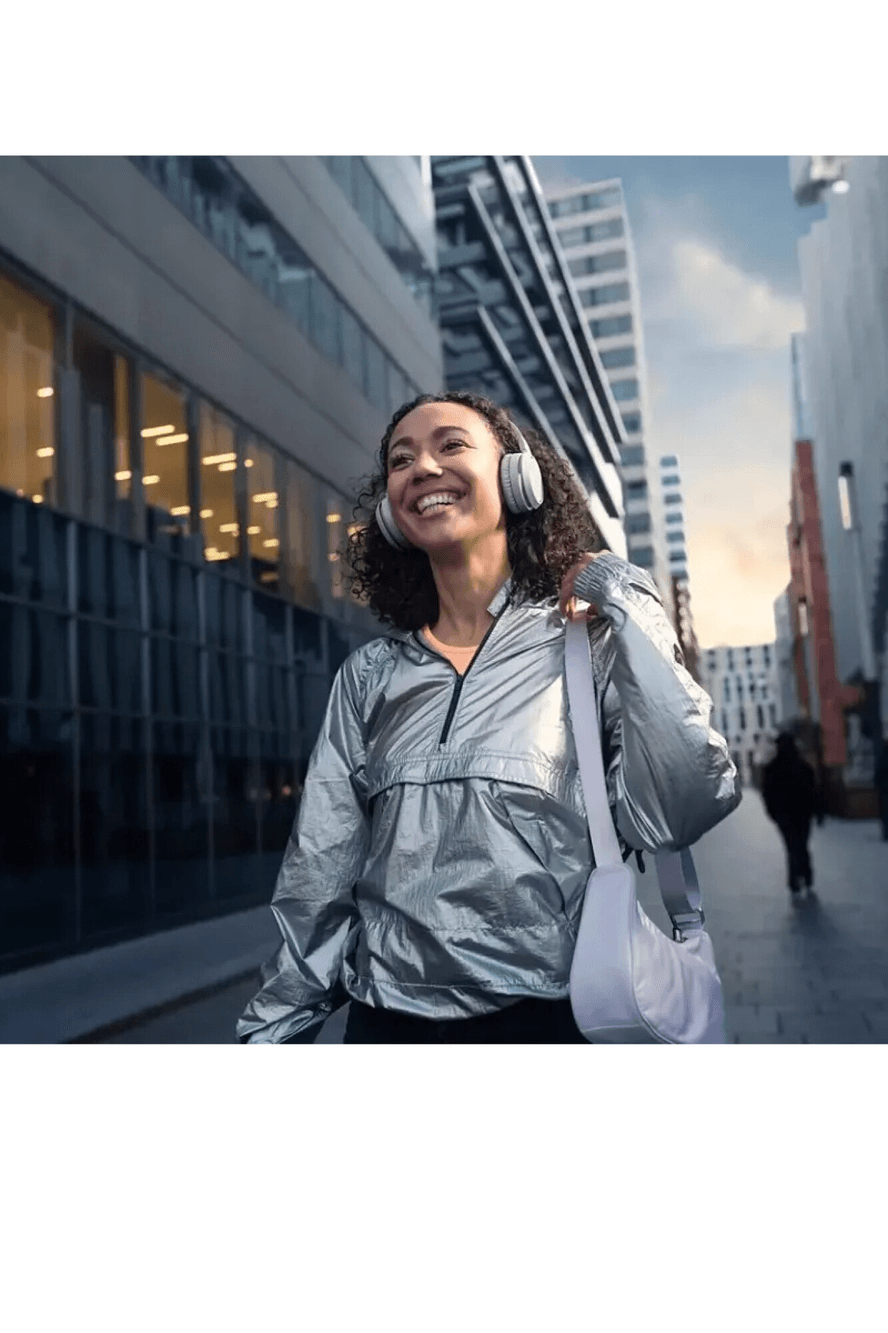 Mujer con auriculares Philips TAH4205WT/00 en la ciudad