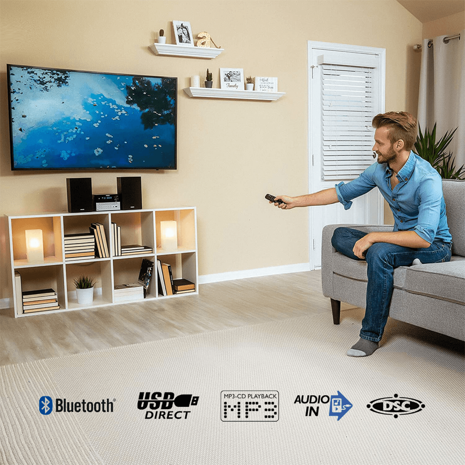 Persona usando el control remoto del microsistema Philips TAM3205M2/77