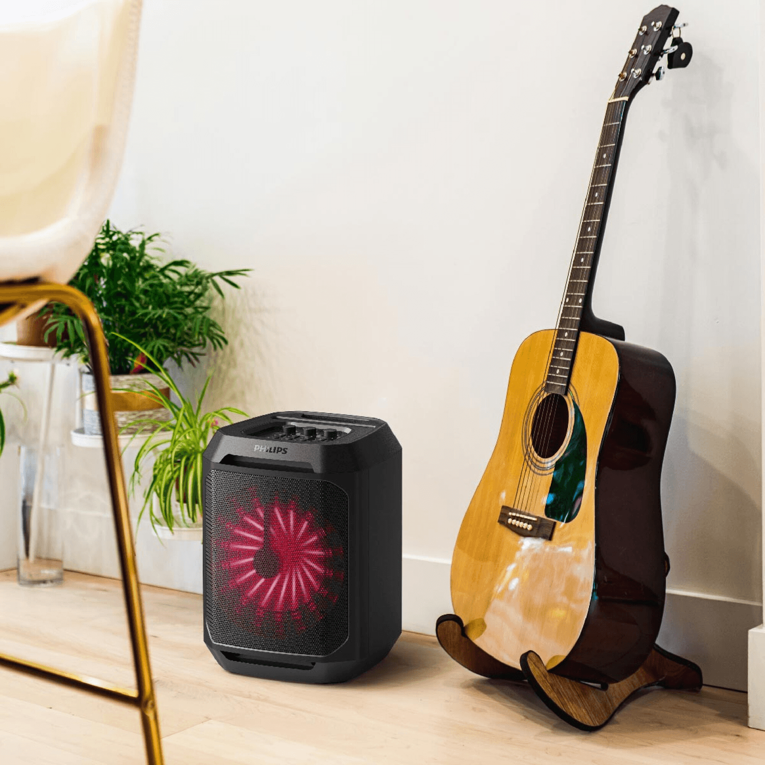 Torre de sonido Philips TAX2208/77 junto a una guitarra